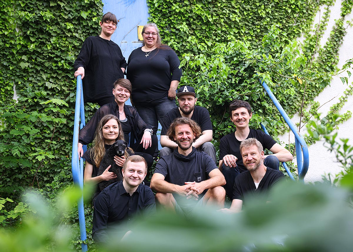 Team photo recable, employees sitting on ivy-covered stairs, mood photo