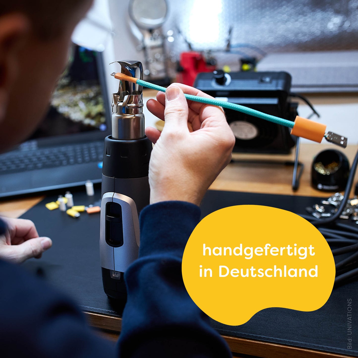 recables fair USB charging cable is made-in-Germany. Illustration: Cable maker René attaches a heat shrink tube by hand with the help of a hot air blower.